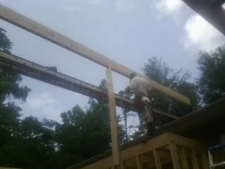 Carpenter setting a ridge beam over a new addition frame — Ice Dam Removal by Roofing Brothers in Maple Park