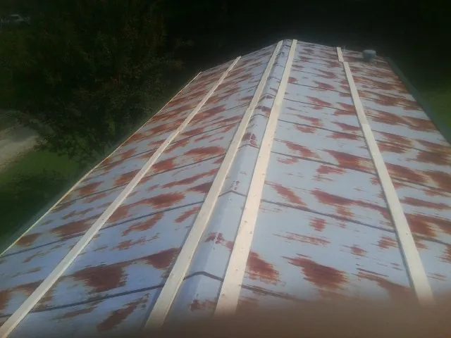 Rusted metal roof panels with new wood purlins before replacement — Storm Damage Roof Repair in Maple Park by Roofing Brothers