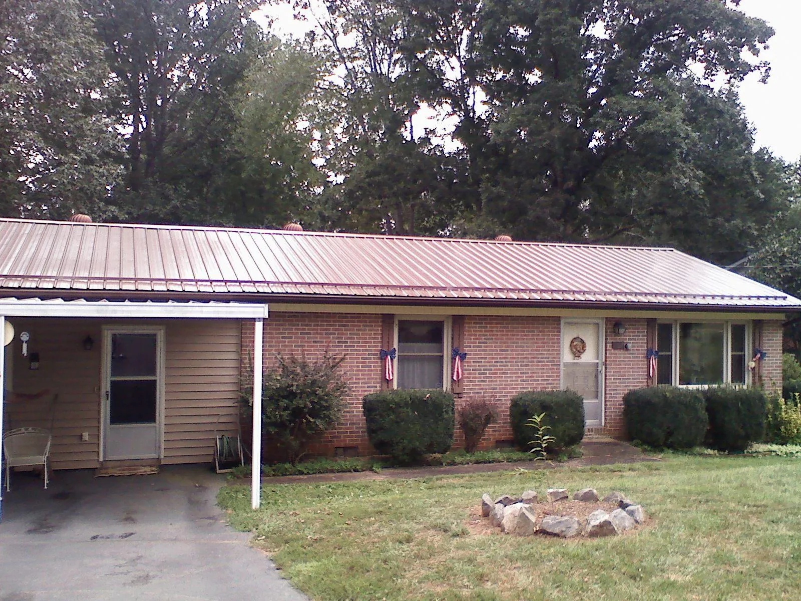 Bronze metal roof and carport on a brick ranch home — Roof Repair work by our crew in Maple Park